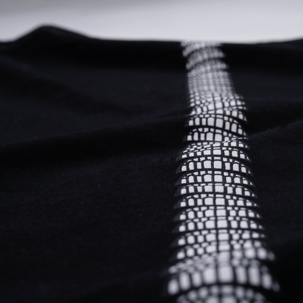 Close-up of a textured black fabric with a white, smile pattern
