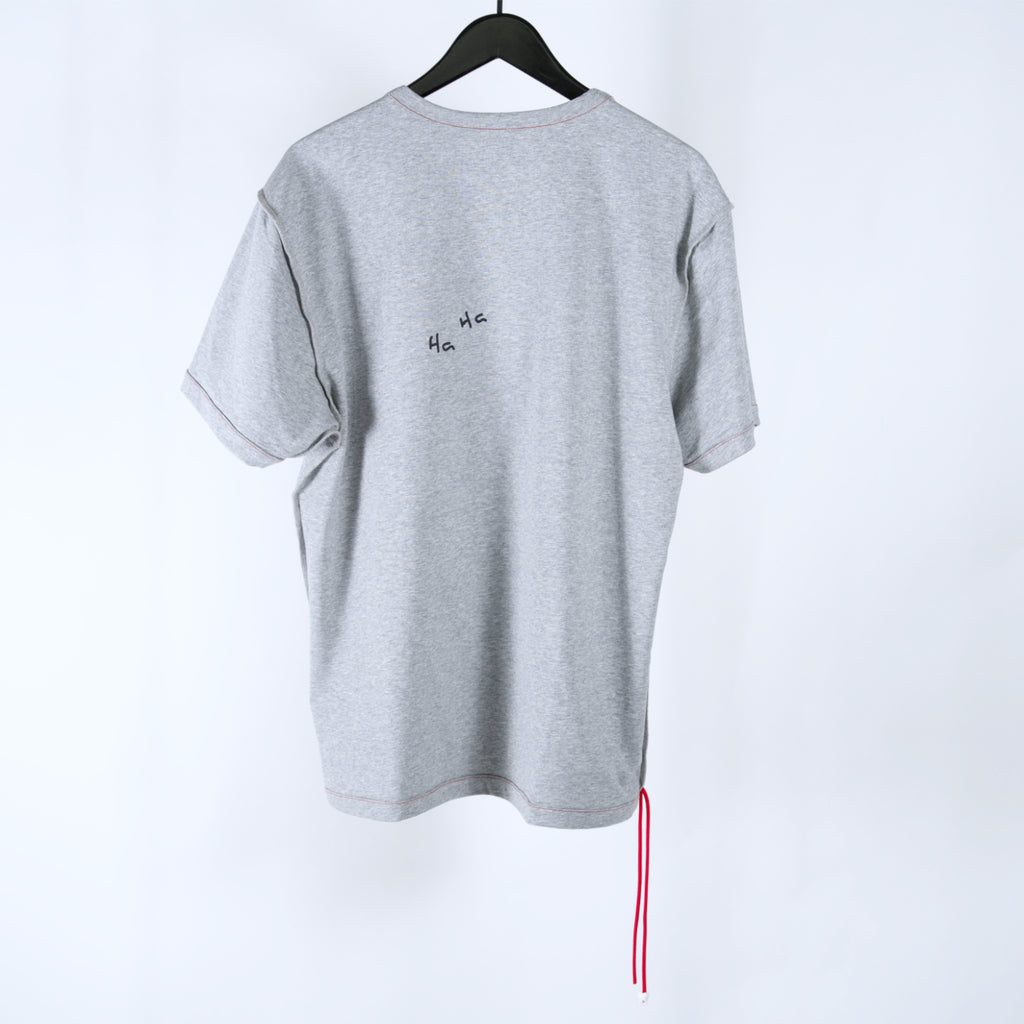 Gray t-shirt on a clothing hanger with two red cords hanging off the bottom and 'Ha Ha' text on the back, on a white background